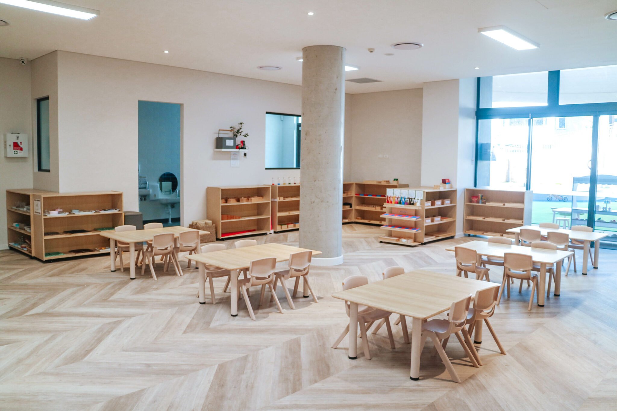 Classroom interior at Montessori Academy’s Lane Cove West childcare, with shelves of learning materials and children’s tables.