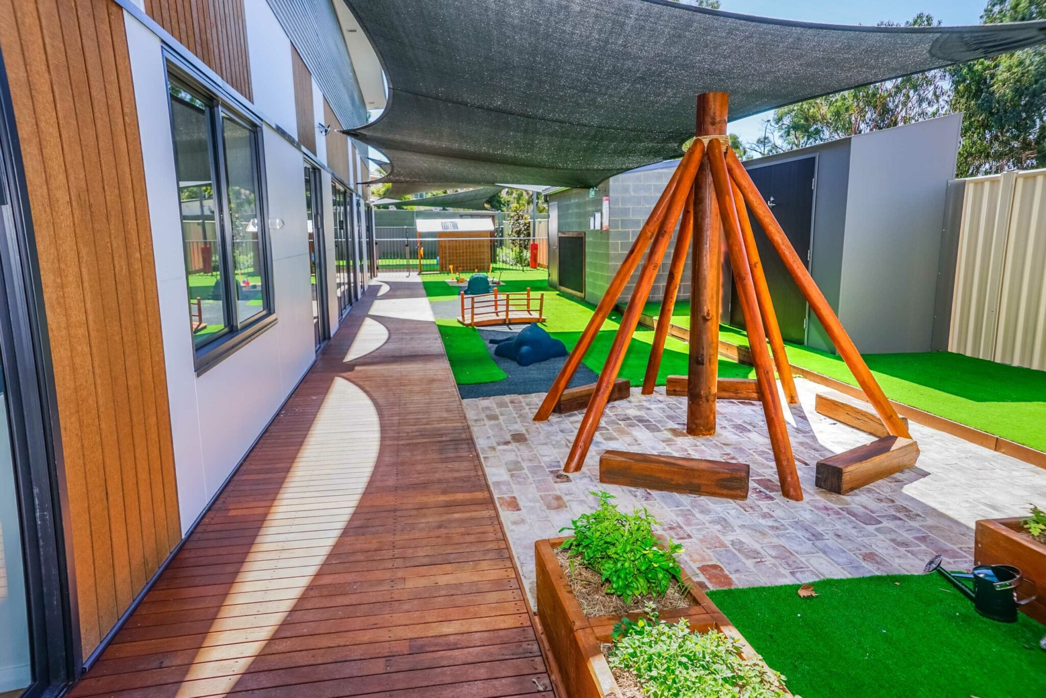 Childcare outdoor area with garden beds and tepee