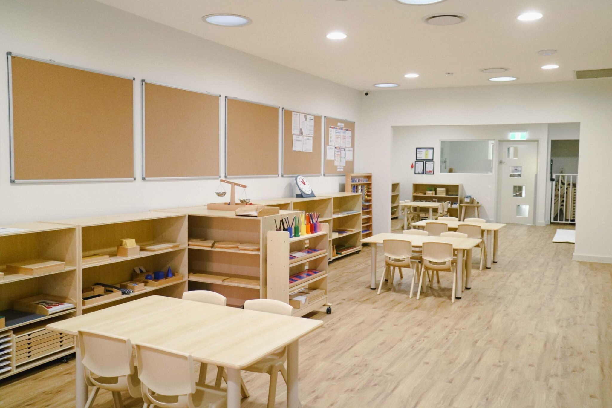 Classroom interior of Montessori Academy’s Guildford childcare, with small tables and shelves with educational materials.