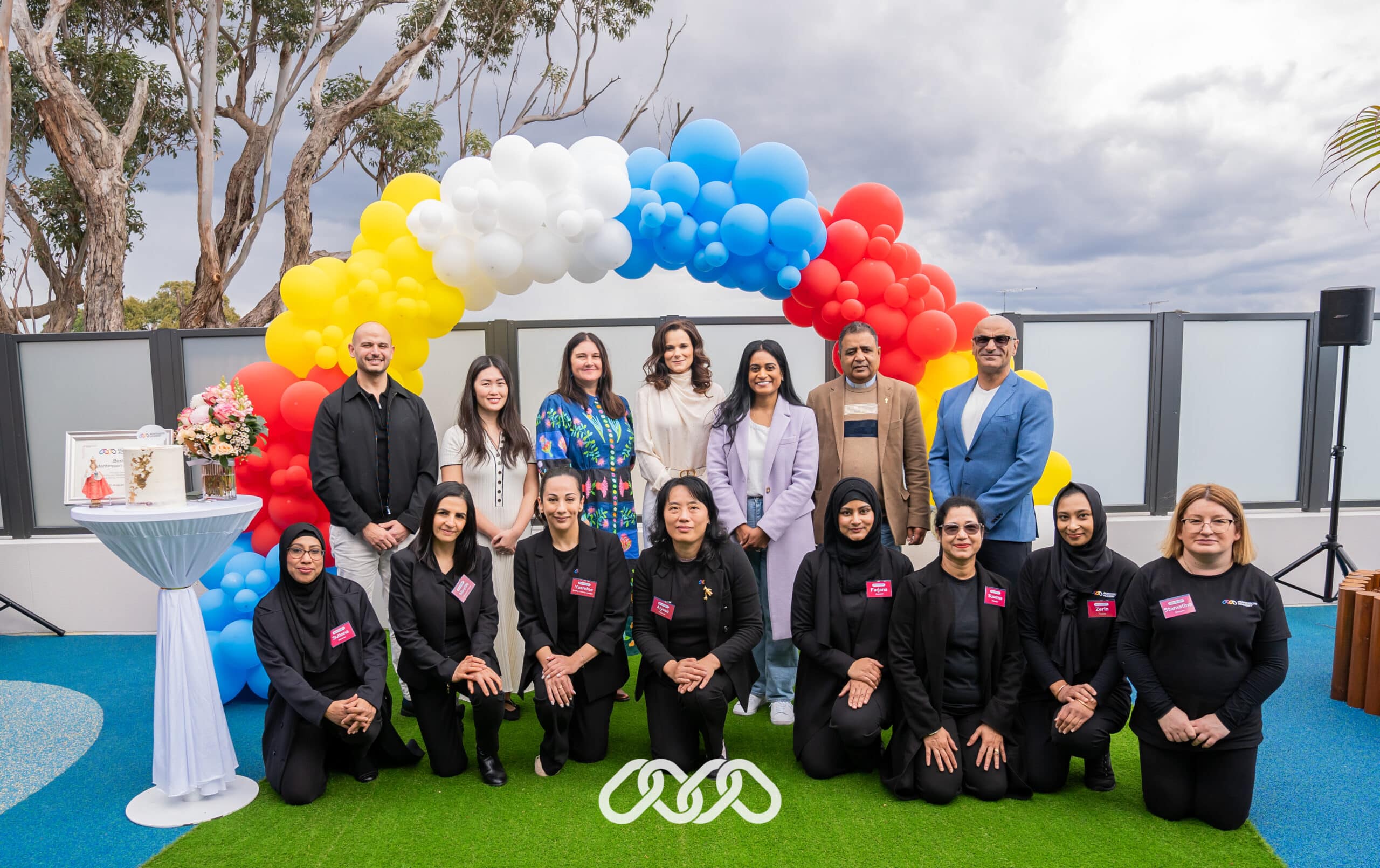 Leadership, community leaders and Bexley team pose for photograph in front of balloon arch at Bexley Montessori Academy grand opening